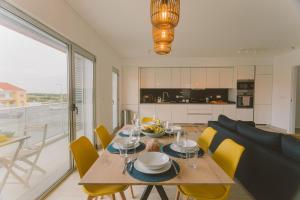 comedor y cocina con mesa y sillas amarillas en Best Houses 25 - Seaside Retreat, en Peniche