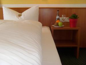 a bed with a table with a bottle of wine and a plate of fruit at Hotel & Restaurant Engel in Herbertingen