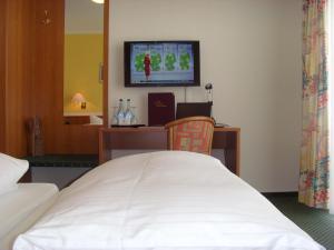 
a bedroom with a bed and a television at Hotel & Restaurant Engel in Herbertingen
