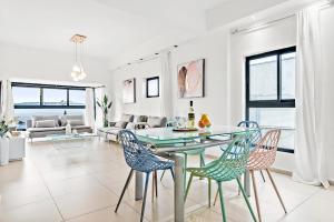 a dining room with a glass table and chairs at GLORIOUS renovated apartment on top of the beach in Tel Aviv
