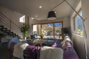 a living room with a purple couch and a tv at Chalet le 1000 Thabor in Valmeinier