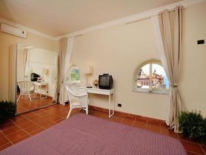 a living room with a tv and a table and a window at Lae Domus in Atrani