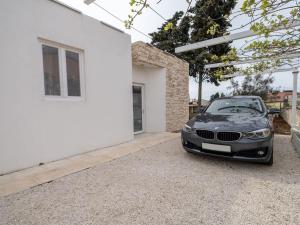 een zwarte auto geparkeerd naast een wit huis bij Villa Sad - prelijepa kuca u srcu Medulina in Medulin