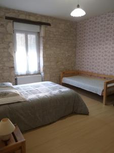 1 dormitorio con 2 camas y ventana en LA LAUJÈRE IVIE - Gîte & Piscine privative, en Saint-Hilaire-du-Bois