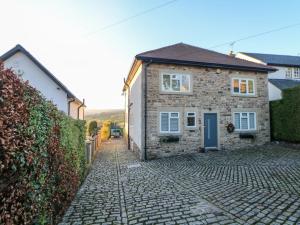 a stone house on a cobblestone street at Glenhurst in Dronfield