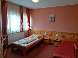 a bedroom with a bed and two tables with lamps at Medgyaszay Panzió in Nagykanizsa