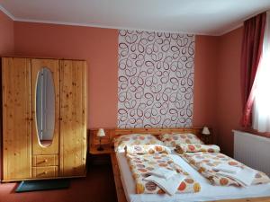 um quarto com uma cama grande e um espelho em Medgyaszay Panzió em Nagykanizsa