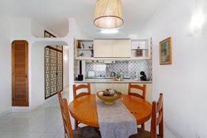 een keuken en eetkamer met een houten tafel en stoelen bij Apartamento AnaMar by Sunnyway in Albufeira