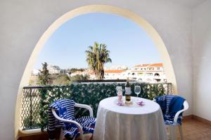 een tafel met stoelen en wijnglazen op een balkon bij Apartamento AnaMar by Sunnyway in Albufeira