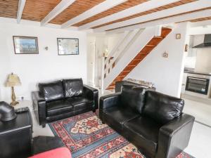 ein Wohnzimmer mit 2 Ledersesseln und einem Teppich in der Unterkunft Ti Sonny in Glinsk