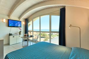 a bedroom with a blue bed and a view of the ocean at JUST SUITES in Cervia