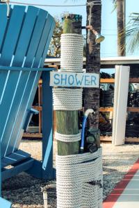 a sign that says showkeeper on a tree next to a blue chair at Captain Pip's Marina & Hideaway in Marathon