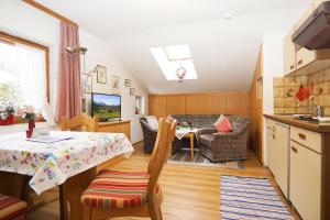 a kitchen and a living room with a table and chairs at Haus Regner in Reit im Winkl