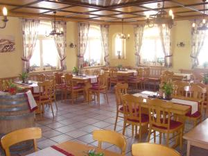 uma sala de jantar com mesas, cadeiras e janelas em Hotel & Restaurant Engel em Herbertingen