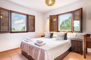 Un dormitorio con una cama con sábanas blancas y ventanas. en Villa Sa Tanca Den Lloses, en Can Furnet 28 fotos más