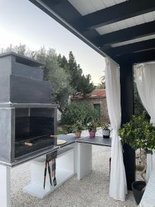 a outdoor kitchen with a grill and a table at Casa Mayra in Los Caparroses