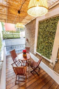 a patio with a table and chairs and a green wall at Eblouissant trois pièces + terrasse in Beausoleil