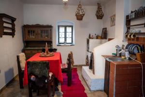 Casa Sub Magrin في Satu Bătrîn: مطبخ مع طاولة مع قماش الطاولة الحمراء