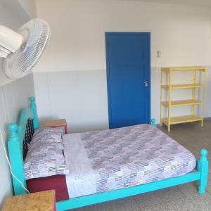 um quarto com uma cama azul e uma ventoinha em rafa's house em Mendoza