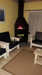 sala de estar con chimenea, 2 sillas y sofá en Yellow Submarine en Franskraal