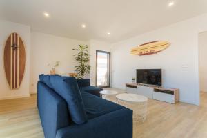 a living room with a blue couch and a tv at Best Houses 29 - Apartamento das Vinhas in Peniche
