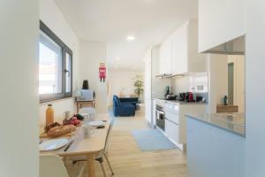 a kitchen and living room with a table and a dining room at Best Houses 29 - Apartamento das Vinhas in Peniche