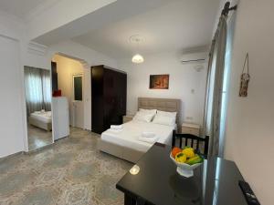 a room with a bed and a table with a bowl of fruit at Levend Apartments in Ksamil