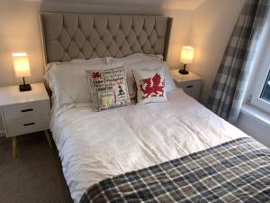 a bedroom with a bed with two night stands and two lamps at Cardiff Coach House with Hot Tub & Log Fire in Cardiff