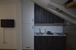 a kitchen with wooden cabinets and a sink at Ancora apartment 5 in Novi Sad