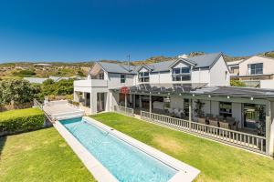 a house with a swimming pool in front of a yard at No2 Merlot in Cape Town