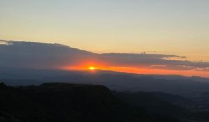 een zonsondergang boven een berg met de zon in de lucht bij Panoramic View Hotel in Lalībela