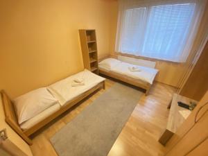 a small room with two beds and a window at ARD City Apartment in Levice