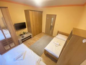 um pequeno quarto com 2 camas e uma televisão em ARD City Apartment em Levice