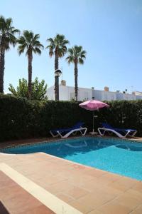 una piscina con 2 sillas y una sombrilla en Spectacular Villa with SwimmingPool in Cala Blanca, en Cala Blanca