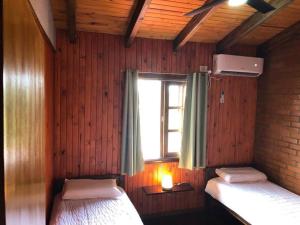 1 dormitorio con 2 camas y ventana. en Hermosa y confortable cabaña en Puerto Iguazú