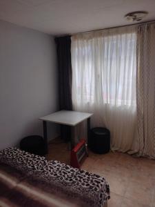 Zimmer mit einem Schreibtisch, einem Tisch und einem Fenster in der Unterkunft apartment Petr Beron in Warna