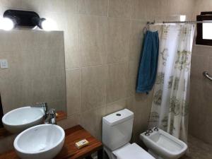 un bagno con un water bianco e un lavandino di Hermosa y confortable cabaña a Puerto Iguazú Altre 25 foto