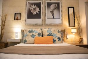 a bedroom with a bed with an orange pillow on it at 28 Peter in Sliema