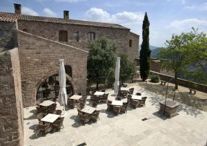 een patio met tafels en stoelen voor een gebouw bij Parador de Cardona in Cardona