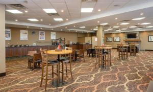 a lobby with tables and chairs in a cafeteria at Pomeroy Hotel Fort St. John in Fort Saint John