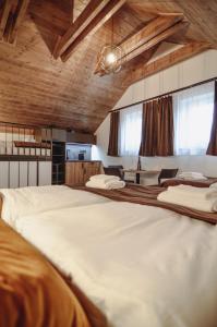 1 cama blanca grande en una habitación con techos de madera. en Skácelův dům, en Valtice