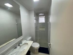a bathroom with a toilet and a sink and a shower at Apartamento ponta das galhetas ( praia Asturias ) in Guarujá