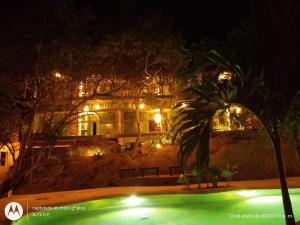 une maison avec une piscine en face de celle-ci la nuit dans l'établissement COCOS HOTEL, à Zipolite