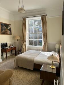 a bedroom with a bed and a window and a desk at Harveys Guest House in Dublin