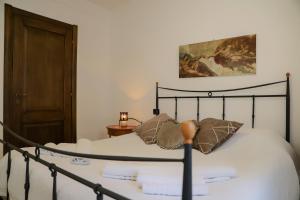 a bed with white sheets and pillows in a room at Il Cuore del Lago in Lazise