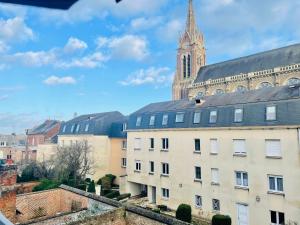 a building with a clock tower and a church at Iflex - 2P à 4P en Duplex - Henriville in Amiens