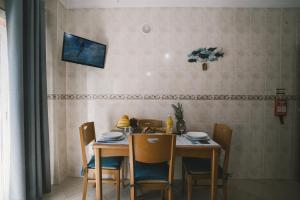 mesa de comedor con sillas y TV en la pared en Best Houses 33 - Conchas do Mar, en Peniche
