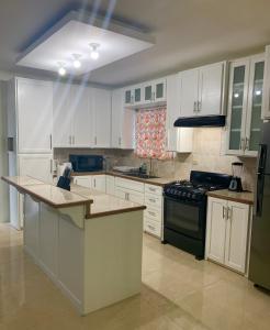 a kitchen with white cabinets and a stove top oven at The Blue Moroccan Door - A modern 3 bedroom,2 bathroom home 