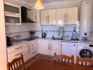a kitchen with white cabinets and a sink and a dishwasher at Large Penthouse Near Porto de Mos Beach With Magnificent Views In Lagos in Lagos