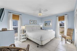 1 dormitorio con 1 cama blanca y paredes azules en Unplugged, en Gulf Shores